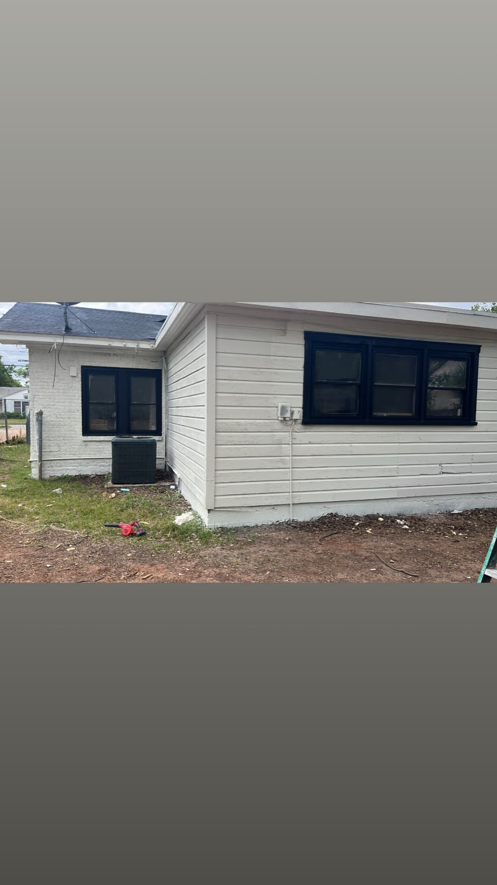 White exterior wall with black window trim after painting
