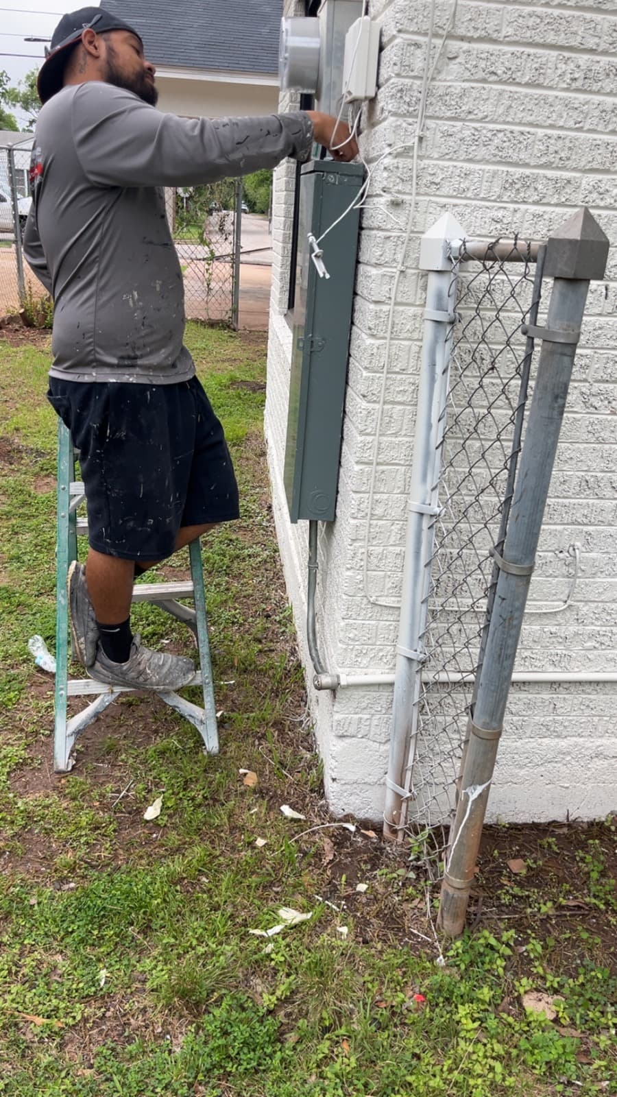 Hermanos Painting team member completing exterior detail work from a ladder